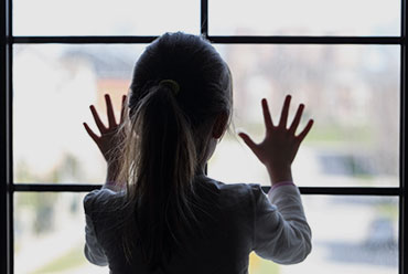 A young girl stands in front of a window - Law Offices Of Anakalia Kaluna Sullivan